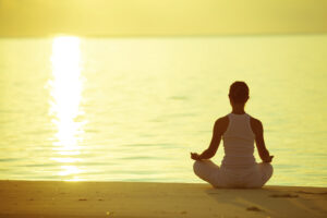 Caucasian woman practicing yoga at seashore